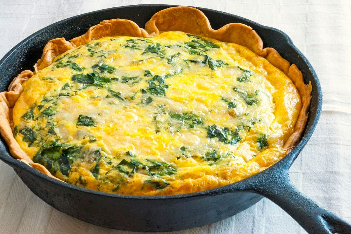 Quiche met spinazie in een gietijzeren pan